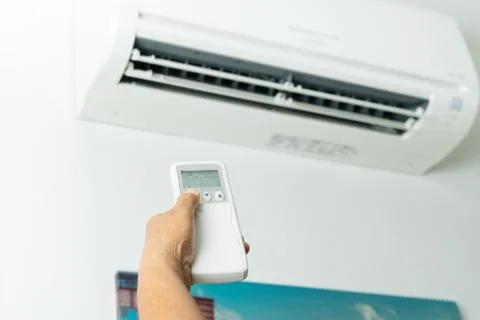 Remote control directed on air conditioner systrem, senior hand control air c Stock Photos