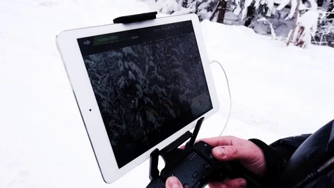 Remote control drone in male hands, closeup. Winter forest. Slo-mo Stock Footage 100815652