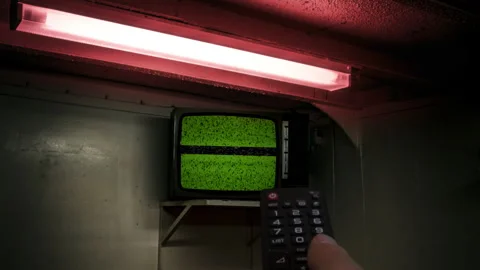 Remote Control Green Screen TV in Dim Basement with Red Fluorescent Light Video stock 318613482