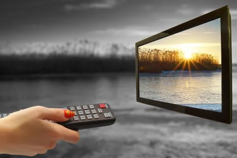 Remote control in hand and TV Stock Photos