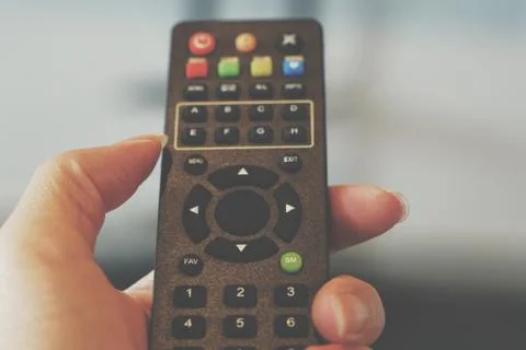 Remote control in the hand with empty middle button Stock Photos
