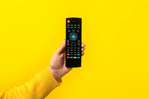 Remote control in hand Stock Photos