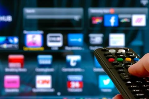 Remote control interacting with smart television Stock Photos