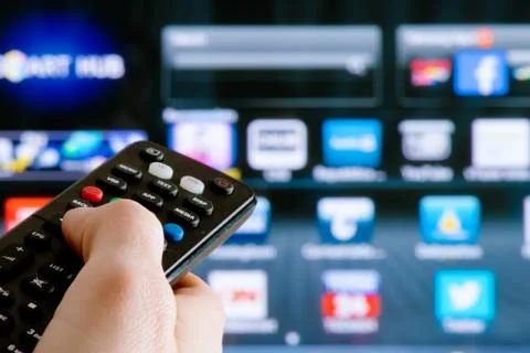 Remote control interacting with smart television Stock Photos