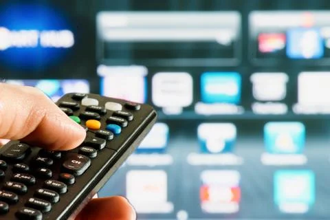 Remote control interacting with smart television Stock Photos