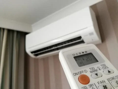 Remote control pointing at air conditioner Stock Photos