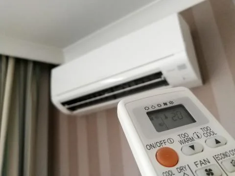 Remote control pointing at air conditioner Stock Photos