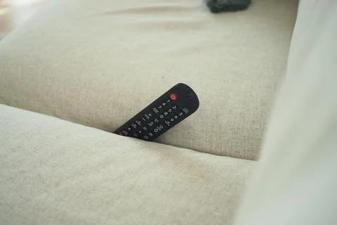 Remote control stuck between couch cushions Stock Photos