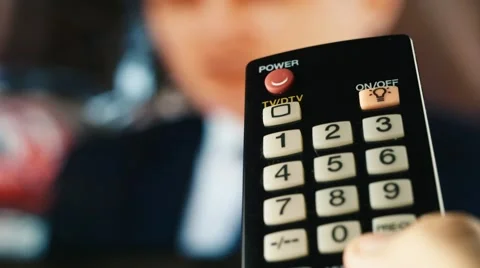 The remote control switches channels on the TV Stock Footage 55012635