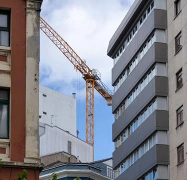 Remote control tower crane working between buildings in Coruna Spain Stock Photos