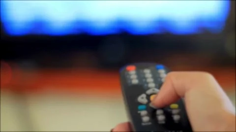 Remote Control used to control TV. Male hand switching channels on TV with .. Stock Footage 257874735