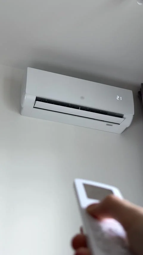 Remote control used by human hand to switch wall conditioner to 17 degrees... Stock-Footage 346155625