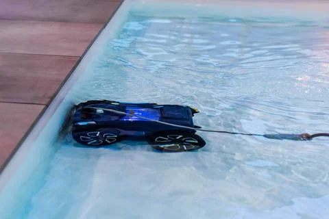 Remote-controlled car navigating through clear water modern swimming pool Stock Photos