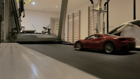 Remote-controlled car on treadmill in gym Stock Footage 101948856