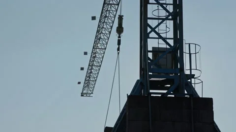 A remote-controlled crane moves through an industrial port in the city of Stock Footage 163039103