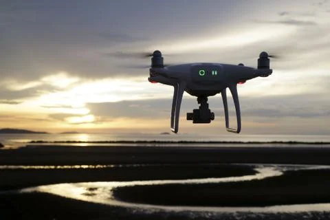 Remote controlled drone flying in air and sunset Stock Photos