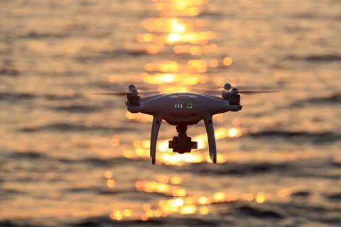 Remote controlled drone flying sparkle sunlight on sea Foto stock