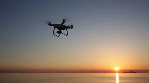 Remote controlled drone flying in the sunset sky Stock Footage 75926254