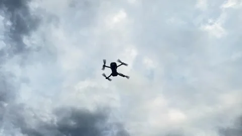 Remote Controlled Drone Hovering Outdoors Against Dramatic Clouds. Stock Footage 336530447