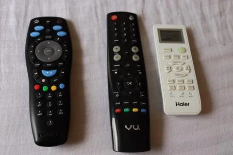 Remote controller are kept together on the bed. Stock Photos