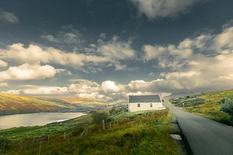 Remote cottage beside road in dramatic Skye landscape Stock Photos