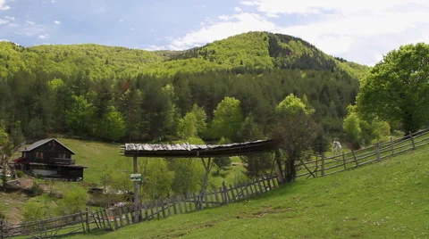 Remote countryside farm, huge wooden door and corral. A white horse gazing at Stock Footage 59358616