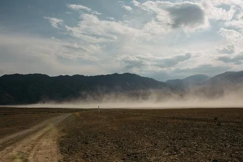 Remote desert landscape with drifting sand and mountains Stock Photos