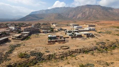 Remote desert village at the foot of rugged mountains Stock Photos