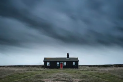Remote desolate isolated house under dark stormy sky during Winter landscap.. Stock Photos