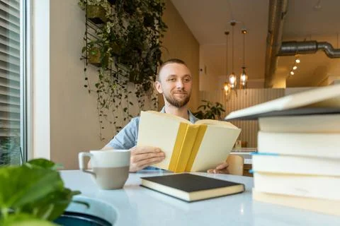 Remote education and study session at a modern cafe with a student reading .. Photos