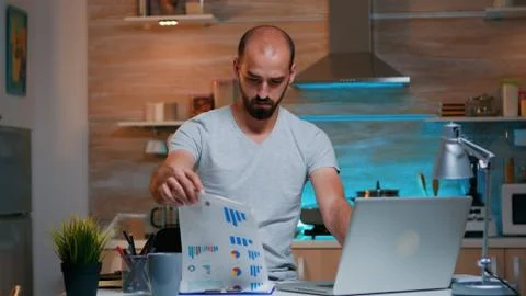 Remote employee checking graphics from clipboard using laptop Stock Photos