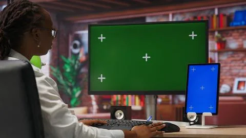 Remote employee in home office using green screen PC and mockup tablet Stock Photos