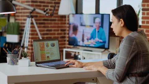 Remote employee optimizing market performance charts at home Stock Photos