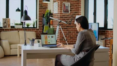 Remote employee optimizing market performance charts at home Stock Photos