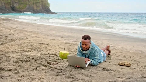 Remote freelance work. Black person type computer laptop near beach. African guy Stock Footage 246407239