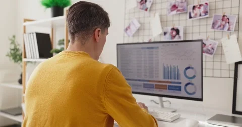 Remote freelancer analyzing data charts on computer at home office workstation Stock Footage 348271898