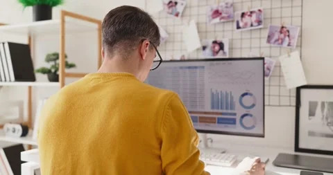 Remote freelancer analyzing data on computer dashboard at home office workspace Stock Footage 348271932
