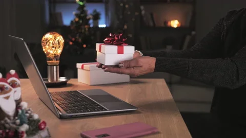 Remote gift exchange close up on hands holding present box to computer screen Stock Footage 163200623