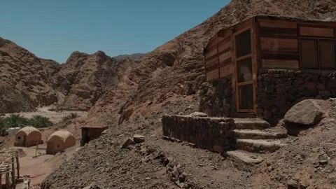 Remote off grid cabin surrounded by dramatic mountains, representing sustainable 스톡 동영상 346247797