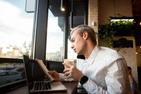 Remote hard work concept. Busy male freelancer looks at the diary, agrees the Foto stock