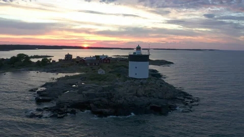 Remote island with active lighthouse and cabins, aerial view during dusk sunset Stock Footage 140411856