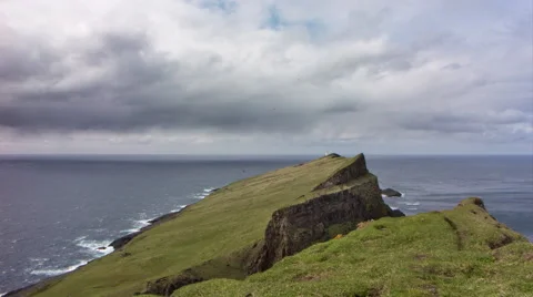Remote island with distant views of a lighthouse on a cliff, 4K time lapse Stock Footage 65306521
