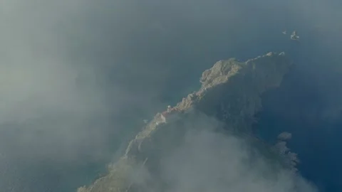 Remote island lighthouse building from sky through clouds Stock Footage 238367999
