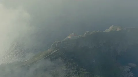 Remote island lighthouse building from sky through clouds Stock Footage 238368073
