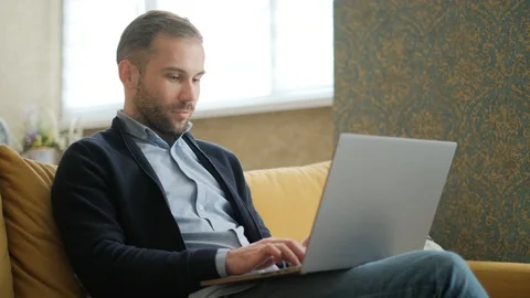 Remote Job. A man is working with documents on laptop remotely at home. A Stock Footage 127586453