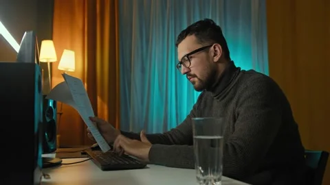 Remote Job. A man is working with documents on laptop remotely at home. A Stock Footage 169282600