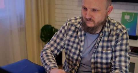 Remote Job. A man is working with documents on laptop remotely at home. A Stock Footage 301525599