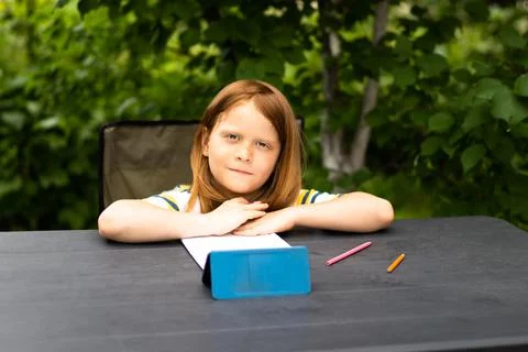 Remote learning child at a table in the garden Stock Photos