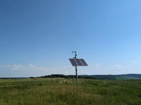 Remote mast with weather sensor webcam and wifi powered by solar panel in open 库存照片