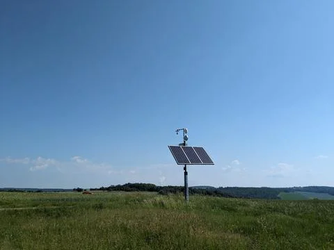 Remote mast with weather sensor webcam and wifi powered by solar panel in open 库存照片